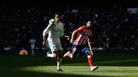 Pemain Real Madrid Varane berebut bola dengan pemain Atletico Madrid Diego Costa saat pertandingan La Liga Spanyol di stadion Santiago Bernabeu di Madrid (8/4). (AP Photo / Francisco Seco)