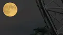 Bulan purnama terakhir tahun ini yang dikenal sebagai Bulan Dingin terbit di sebelah kapsul bianglala London Eye di London, Rabu (7/12/2022). Bulan purnama Desember juga akan berada di atas cakrawala lebih lama dari kebanyakan Bulan purnama, karena lintasannya yang lebih tinggi di langit. (AP Photo/Alastair Grant)