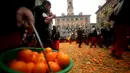 Peserta membawa jeruk saat perang-perangan selama karnaval di kota Ivrea, Italia, Minggu (7/2). Peserta yang dibagi menjadi dua tim ini saling melempar jeruk menggunakan kostum dan aksesoris lengkap. (REUTERS/Stefano Rellandini)