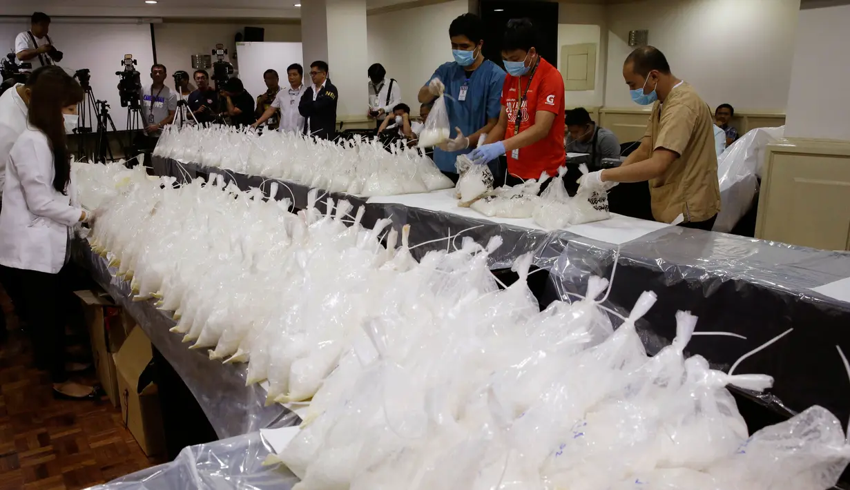 Petugas menata barang bukti penyelundupan narkoba di Kantor Biro Investigasi Nasional Filipina, Senin (29/5). Petugas Filipina menyita 600 kilogram metamfetamin yang diselundupkan dari China dengan nilai sekitar USD 121,4 juta. (AP Photo/Aaron Favila)