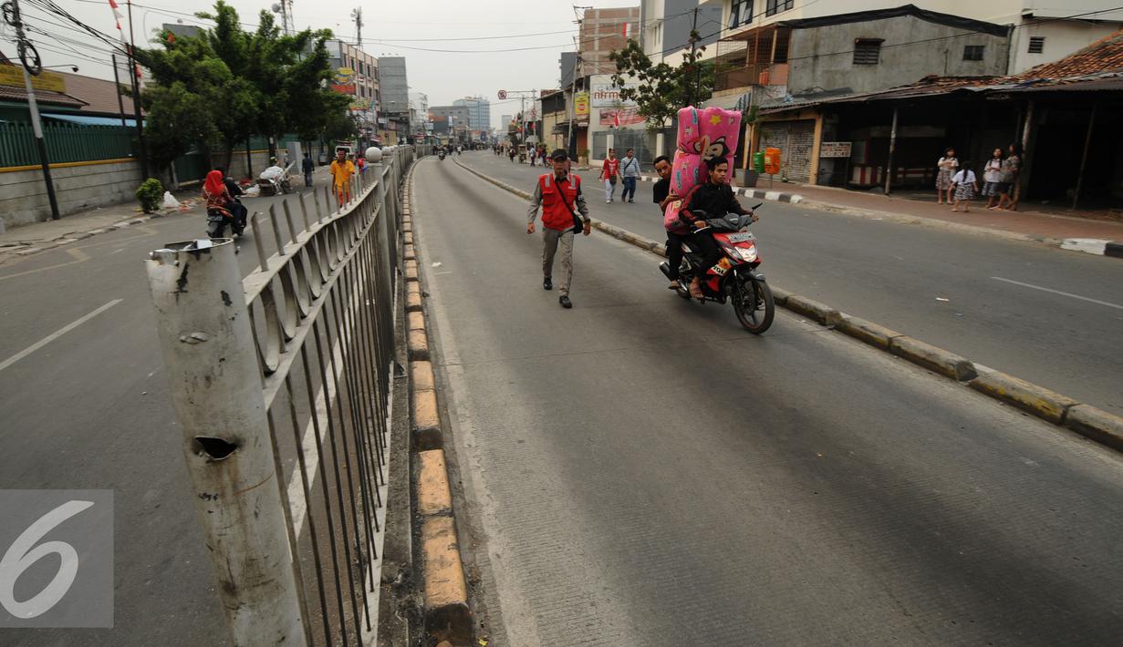Warga melintas di Jalan Jatinegara Barat Jakarta, Kamis (20/8/2015). Jalan Jatingara Barat Barat ditutup saat penggusuran warga yang tinggal di bantaran Kali Ciliwung, Kampung Pulo, Jakarta Timur. (Liputan6.com/Helmi Fithriansyah)