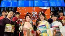 Sejumlah wanita mengenakan busana kimono berpose setelah pembukaan pasar saham untuk tahun ini di Bursa Saham Tokyo, Jepang (4/1). Mereka hadir sebagai bagian dari upacara pembukaan bursa saham yang digelar setiap awal tahun. (AP Photo/Eugene Hoshiko)