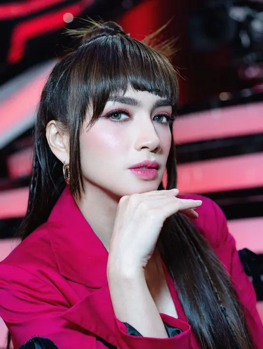 Penampilan berbeda Angel Karamoy dengan wig poni dan nuansa warna fuchsia yang terlihat pas di wajahnya. Pulasan lipstik, eyeshadow, dan perona pipi serasi dengan blazer yang dikenakannya. Foto: Instagram.