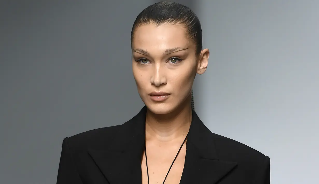 Model Bella Hadid mengenakan membawakan koleksi Spring 2020 dari Mugler dalam gelaran Paris Fashion Week, Rabu (25/9/2019). Bella Hadid menonjolkan bentuk alis serta matanya yang dirias ala smokey eye, dengan sapuan warna emas pada bibirnya. (Christophe ARCHAMBAULT / AFP)