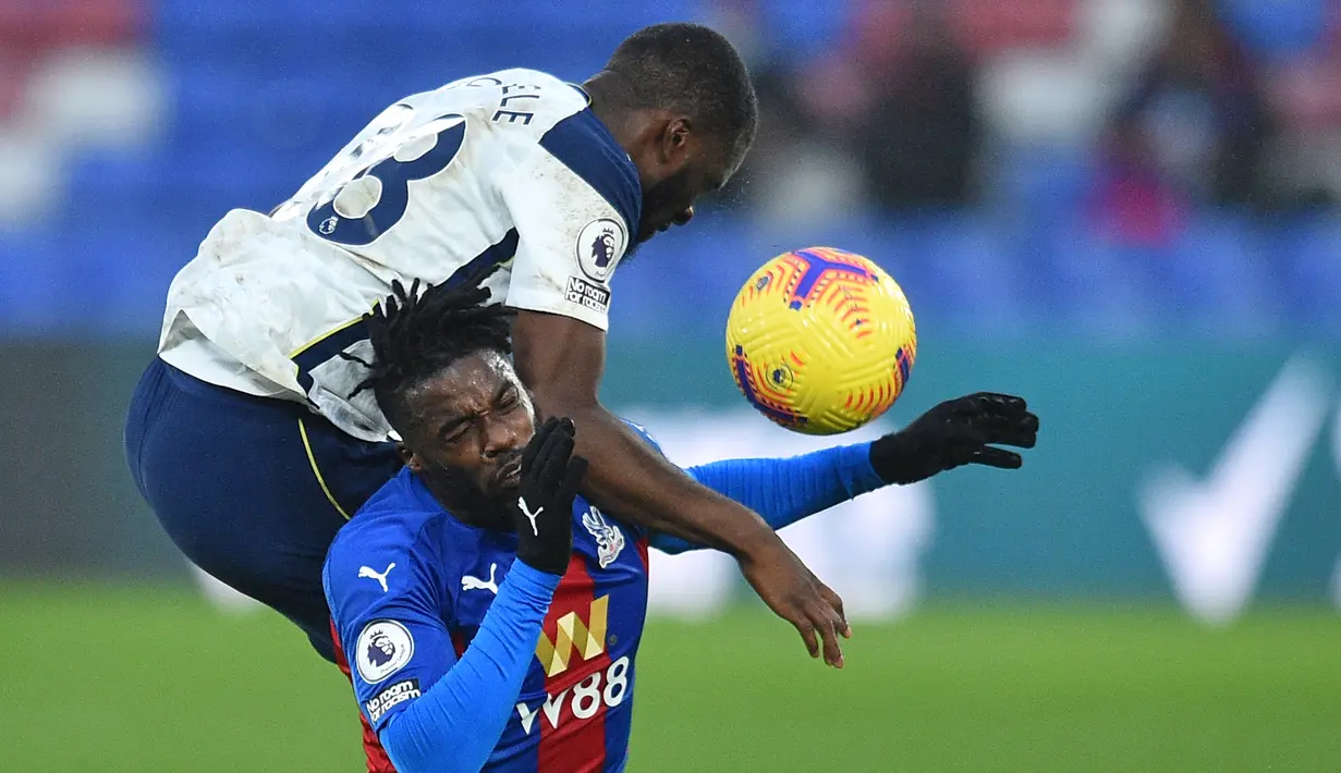 Gelandang Tottenham Hotspur, Tanguy Ndombele (atas), berduel udara dengan gelandang Crystal Palace, Jeffrey Schlupp dalam laga lanjutan Liga Inggris 2020/21 pekan ke-12 di Selhurst Park Stadium, Minggu (13/12/2020). Tottenham bermain imbang 1-1 dengan Palace. (AFP/Glyn Kirk/Pool)