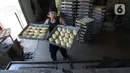 Pekerja membawa adonan roti di industri rumahan Lengansari, Duren Sawit, Jakarta, Rabu (26/8/2020). Industri rumahan tersebut mampu memproduksi 3.000 roti per hari dengan harga jual Rp. 2.000 per buah. (merdeka.com/Imam Buhori)