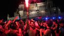 Pendukung Italia merayakan kemenangan di Roma, Italia pada Senin (12/07/2021), setelah Italia berhasil mengalahkan Inggris pada Final Euro 2020 yang berlangsung di Stadion Wembley, London, Inggris. Italia mengalahkan Inggris 3-2 dalam adu penalti setelah bermain imbang 1-1. (AP/Alessandra Tarantino)