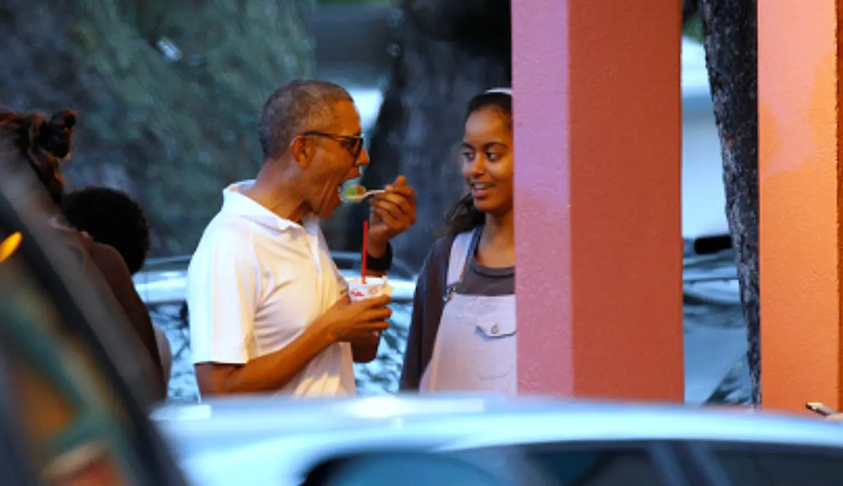 Presiden AS, Barack Obama berbincang dengan putri sulungnya, Malia sambil menikmati es serut saat libur Natal di Kailua, Hawai, AS, (24/12). Obama dan keluarganya akan berlibur selama 17 hari hingga awal Januari 2017. (REUTERS/Kevin Lamarque)