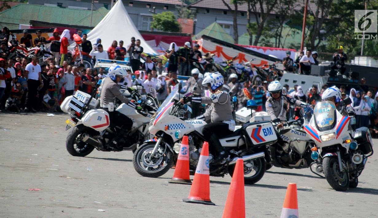 Sejumlah anggota Satlantas Polda Gorontalo beratraksi menggunakan motor gede selama Road Safety Festiva Millenial Gorontalo di Lapangan Taruna Remaja Kota Gorontalo, Minggu (10/2). (Liputan6.com/Rahmad Arfandi Ibrahim)