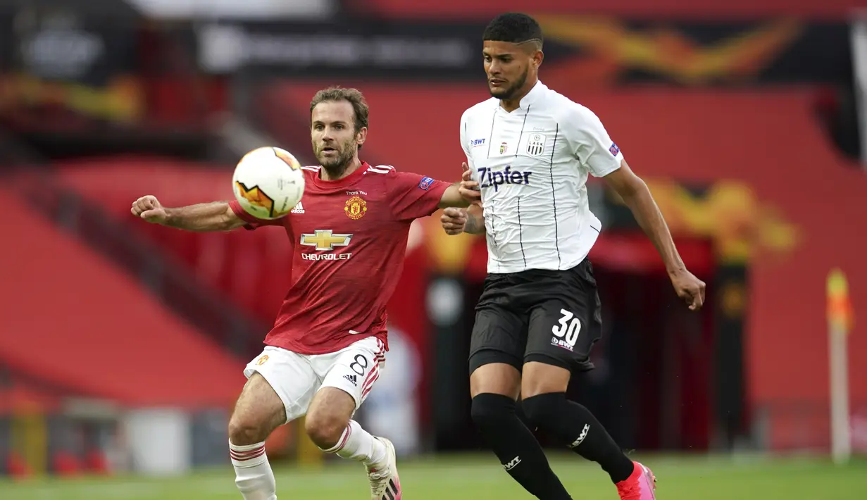 Gelandang Manchester United, Juan Mata mengontrol bola dari kawalan pemain LASK, Andres Andrade pada pertandingan leg kedua babak 16 besar Liga Europa di Stadion Old Trafford, Inggris (6/8/2020). MU menang 2-1 atas Lask dan melaju ke perempat final.  (AP Photo/Dave Thompson)