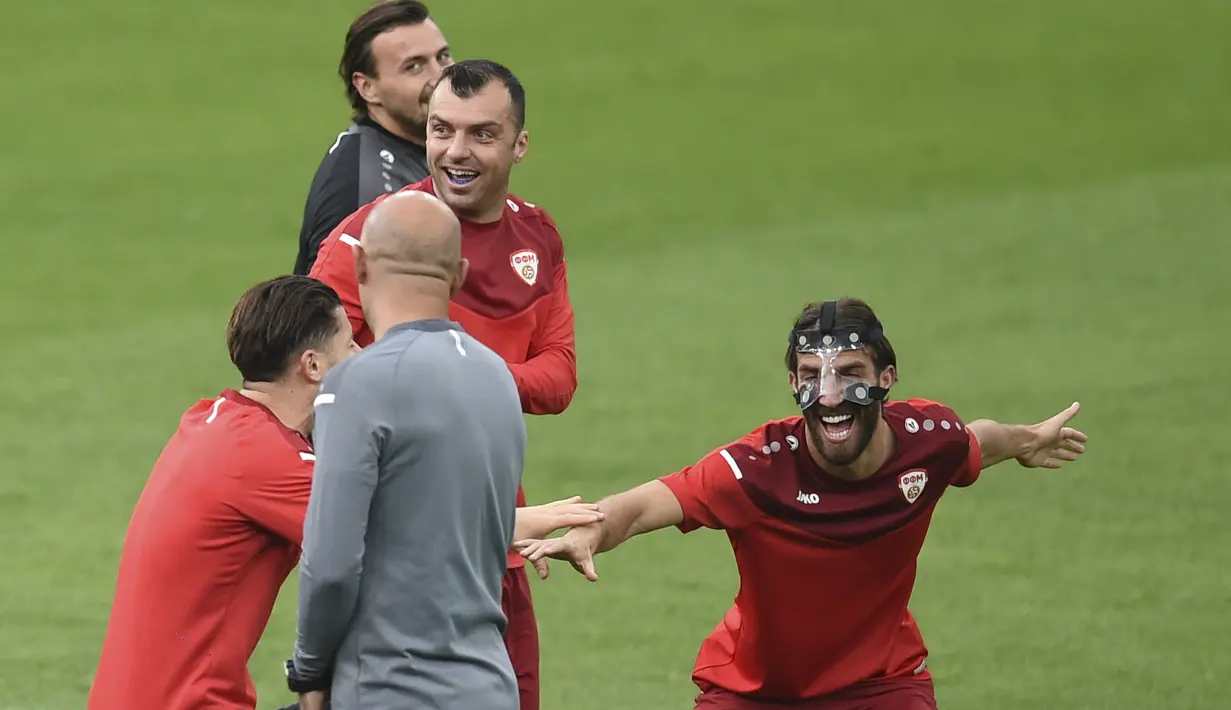 Ferhan Hasani dari timnas Makedonia Utara (kanan) tertawa selama sesi latihan di stadion National Arena di Bucharest, Sabtu (12/6/2021). Timnas Austria akan berhadapan dengan sang debutan Makedonia Utara di matchday 1 Grup C Euro 2020, Minggu (13/6) malam pukul 23.00 WIB. (Mihai Barbu, Pool via AP)