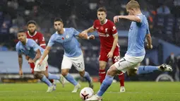 Gelandang Manchester City, Kevin De Bruyne melakukan tendangan penalti ke gawang Liverpool pada pertandingan Liga Inggris pekan ke-8 di Etihad Stadium, Minggu (8/11/2020). City gagal mengalahkan Liverpool dan harus puas berbagi angka setelah bermain imbang 1-1. (Clive Brunskill/Pool via AP)