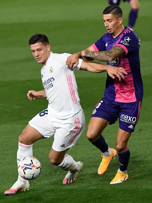 Bek Valladolid Javi Sanchez (tengah) menantang penyerang Real Madrid, Luka Jovic pada lanjutan La Liga Spanyol di stadion Alfredo, Rau (30/9/2020). Real Madrid menekuk Real Valladolid denga skor 1-0. (PIERRE-PHILIPPE MARCOU / AFP)