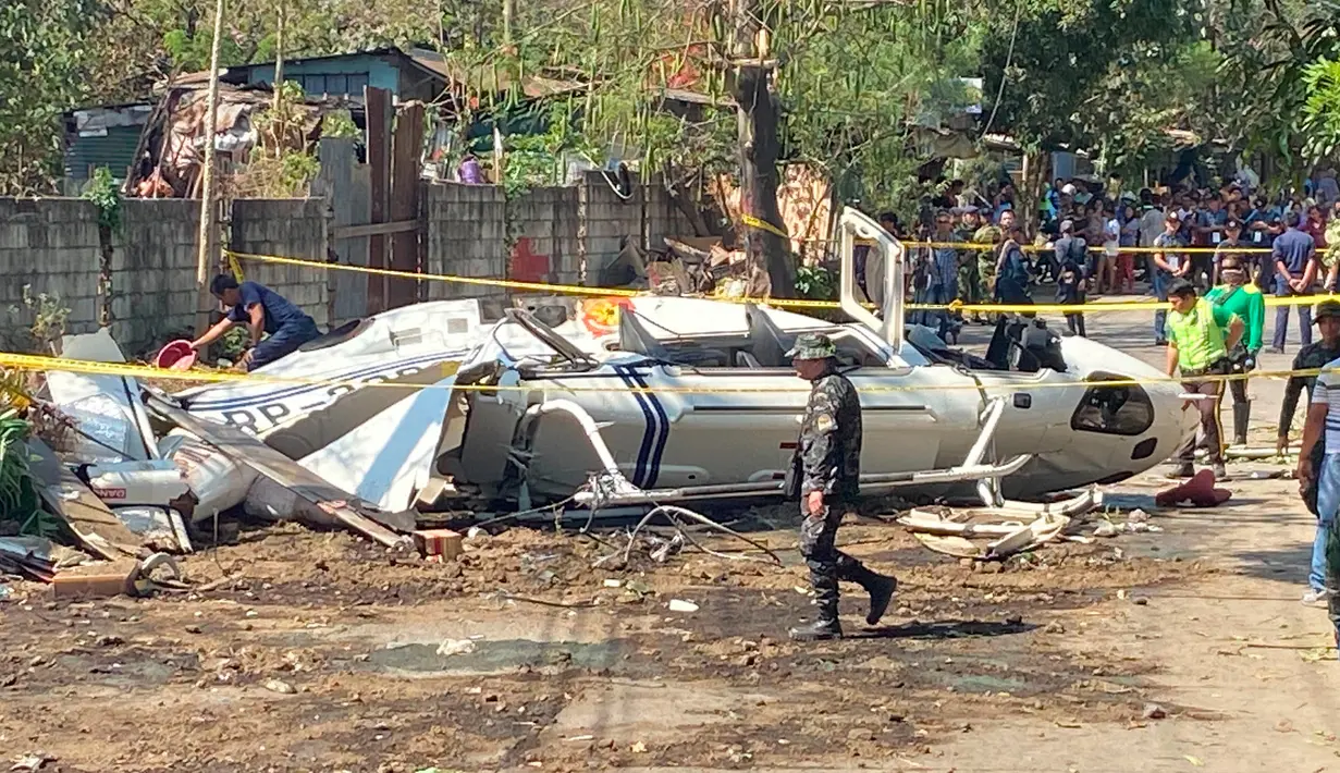 Lokasi jatuhnya Helikopter bell 429 yang membawa kepala polisi Filipina ditutup di San Pedro, selatan Manila, Kamis (5/3/2020). Saat helikopter lepas landas, debu beterbangan dan menciptakan awan debu tebal hingga mempengaruhi visibilitas di daerah tersebut.  (AP/Aaron Favila)