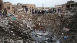 Warga sipil berkumpul di lokasi ledakan di Kota Sadr di Baghdad, Irak, (7/6). Sepasang ledakan tersebut menghancurkan sebuah masjid di distrik mayoritas Syiah di Baghdad yang menewaskan dan melukai warga sipil termasuk anak-anak. (AP Photo/Karim Kadim)