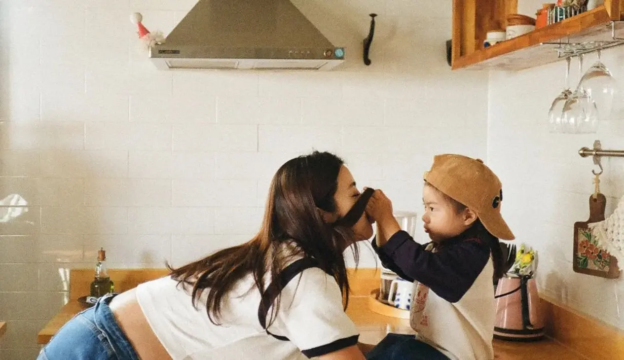 Kang Sora padukan t-shirt dan unzipped mini skirt denim. Sementara putri pertamanya kenakan outfit serupa dengan gaya yang lebih boyish dari sang ibu [@reveramess_]