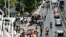 Sejumlah warga dan polisi berkumpul di lokasi ledakan di Bangkok (2/8/2019). Sedikitnya ada lima lokasi atau titik ledakan. Seperti di bawah halte BTS (Bangkok Sky Train) Chong Nonsi, persimpangan 57/1 Jalan Rama IX. (AFP Photo/Lillian Suwanrumpha)