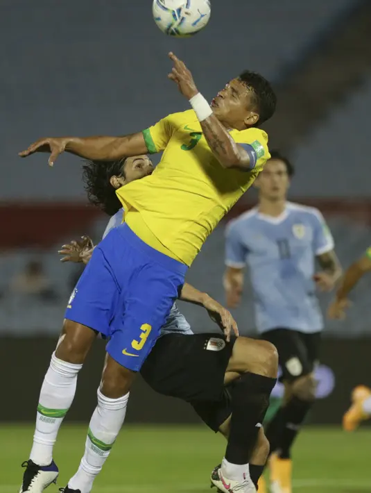 Bek Brasil, Thiago Silva berebut bola dengan penyerang Uruguay, Edinson Cavani pada pertandingan keempat kualifikasi Piala Dunia 2022 zona CONMEBOL di Estadio Centenario, Montevideo, Selasa (17/11/2020). Brasil menang atas Uruguay 2-0. (AP Photo/Matilde Campodonico, Pool)