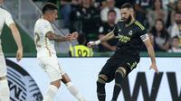 Nicolas Fernandez Mercau dari Elche, kiri, menantang Karim Benzema dari Real Madrid selama pertandingan sepak bola La Liga Spanyol antara Elche dan Real Madrid di Stadion Martinez Valero di Elche, Spanyol, Rabu, 19 Oktober 2022. (AP Photo/Alberto Saiz)