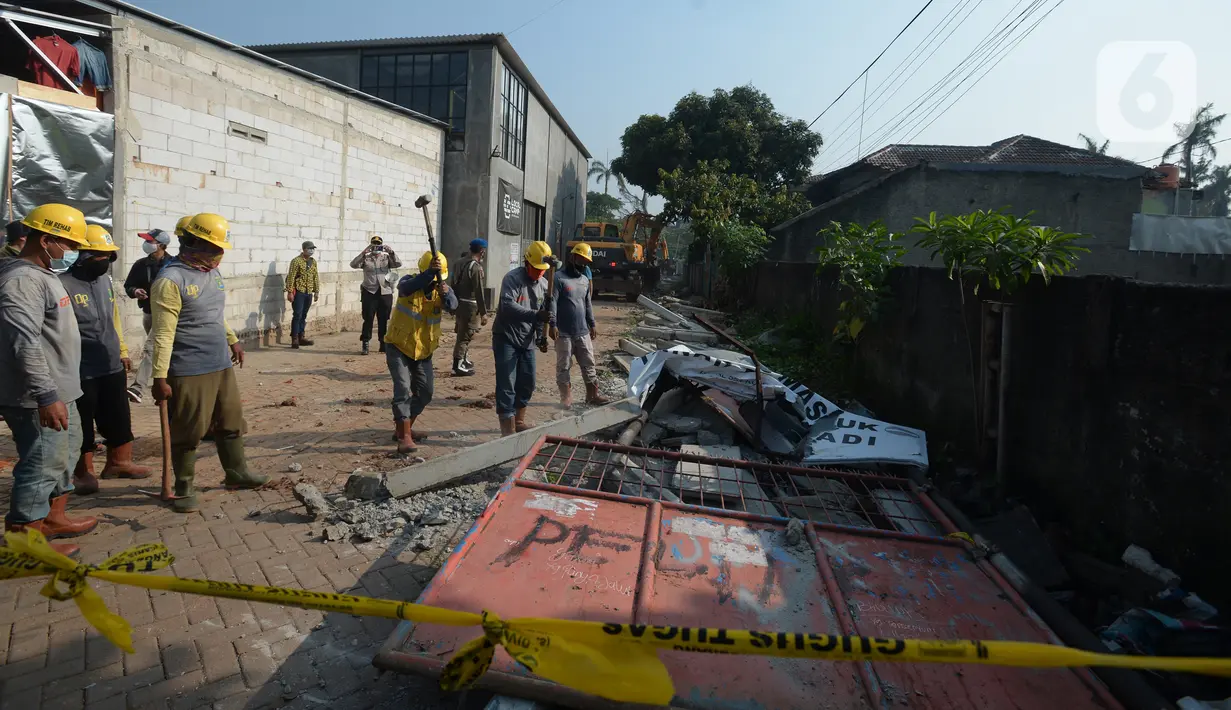Para pekerja merobohkan pagar beton yang mengisolasi sejumlah warga di Jalan Akasia, Tajur Ciledug, Tangerang, Banten, Rabu ( 17/3/2021). Pagar beton yang sempat menutup akses jalan warga tersebut kini dibongkar. (merdeka.com/Imam Buhori)