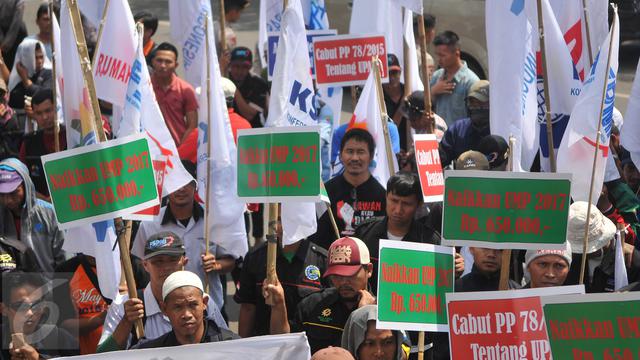 <span>Aksi massa buruh yang tergabung dalam Konfederasi Serikat Pekerja Indonesia (KSPI) di Balai Kota DKI Jakarta, Rabu (1/6). Mereka menuntut kenaikan upah minimum DKI sebesar Rp 650 ribu. (Liputan6.com/Gempur M Surya)</span>