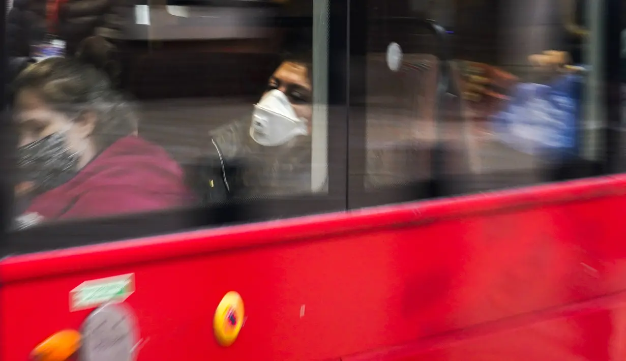 Seorang wanita mengenakan masker saat dia duduk di bus, di London, Kamis (16/12/2021). Kepala petugas medis Inggris memperingatkan Situasi kemungkinan akan bertambah buruk karena varian omicron mendorong gelombang penyakit baru selama liburan Natal. (AP Photo/Alberto Pezzali)