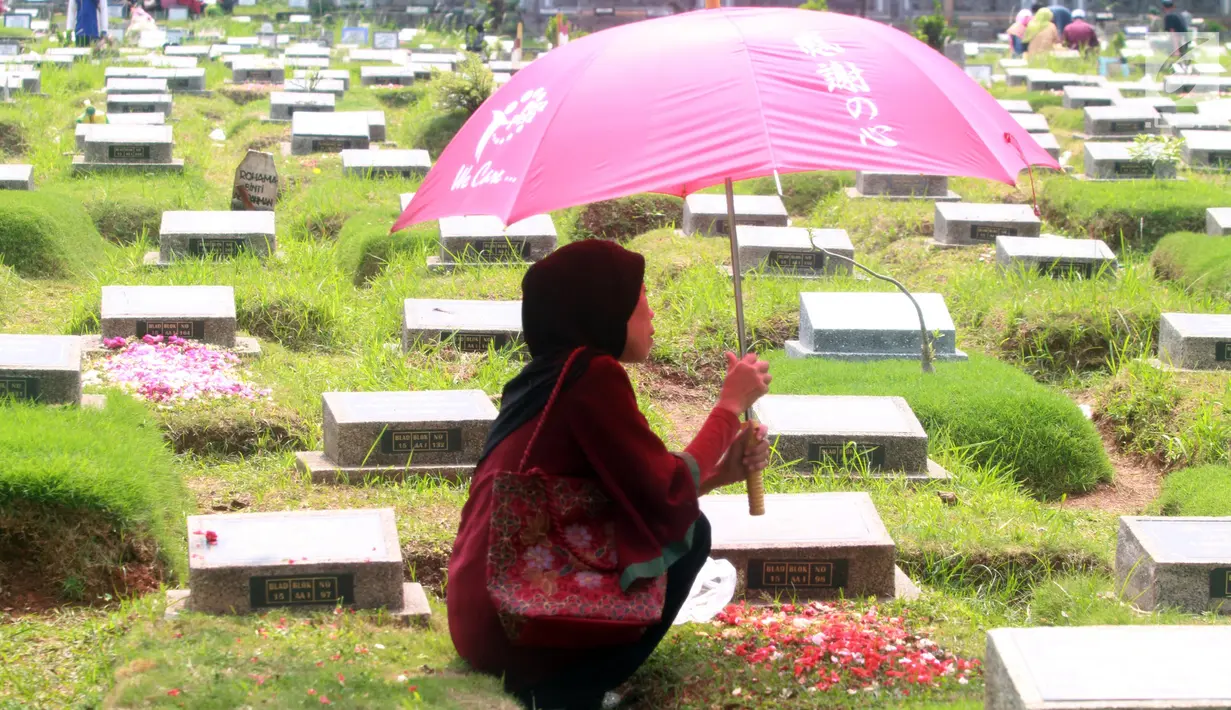 Warga berdoa saat berziarah di TPU Karet Pasar Baru Barat, Jakarta, Sabtu (16/6). Ziarah kubur atau "nyekar" pada hari raya lebaran merupakan salah satu tradisi umat muslim untuk mendoakan sanak keluarga yang meninggal dunia. (Liputan6.com/Arya Manggala)
