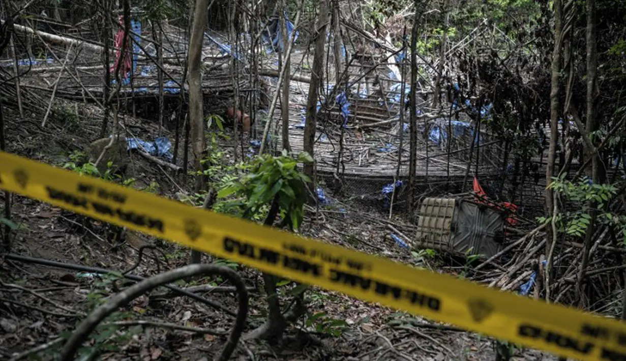 Sebuah garis kepolisian telah dipasang di lokasi base camp penyelundupan manusia di Bukit Wang Burma dekat perbatasan Malaysia-Thailand, (26/5/2015). 139 kuburan massal yang berisi kerangka orang ditemukan.  (AFP PHOTO/MOHD RASFAN)