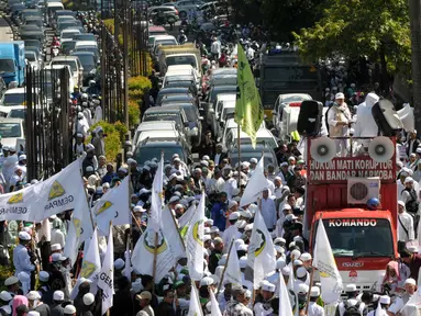 Sejumlah Massa FPI memblokir jalan ke arah menteng dari kuningan saat mengelar aksi, Jakarta, Senin (4/4). Dalam Aksinya tersebut mendesak agar di periksannya Gubernur Jakarta, Ahok terkait Korupsi Rs Sumber waras. (Liputan6.com/Helmi Afandi)