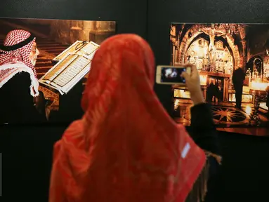 Pengunjung memotret karya dalam pameran foto Yerussalem di Hotel Borobudur, Jakarta, Senin (14/12/2015). Pameran foto tersebut menceritakan kehidupan sehari-hari di kota suci tersebut antara umat Muslim dan Nasrani. (Liputan6.com/Faizal Fanani)