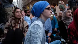 Umat muslim dan aktivis pendukung menunggu waktu berbuka puasa di dekat Trump Tower, New York, Kamis (1/6). Ratusan muslim berdemo memprotes retorika dan kebijakan Donald Trump yang xenophobia, seperti larangan perayaan Ramadan di AS. (Jewel SAMAD/AFP)