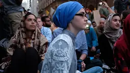 Umat muslim dan aktivis pendukung menunggu waktu berbuka puasa di dekat Trump Tower, New York, Kamis (1/6). Ratusan muslim berdemo memprotes retorika dan kebijakan Donald Trump yang xenophobia, seperti larangan perayaan Ramadan di AS. (Jewel SAMAD/AFP)