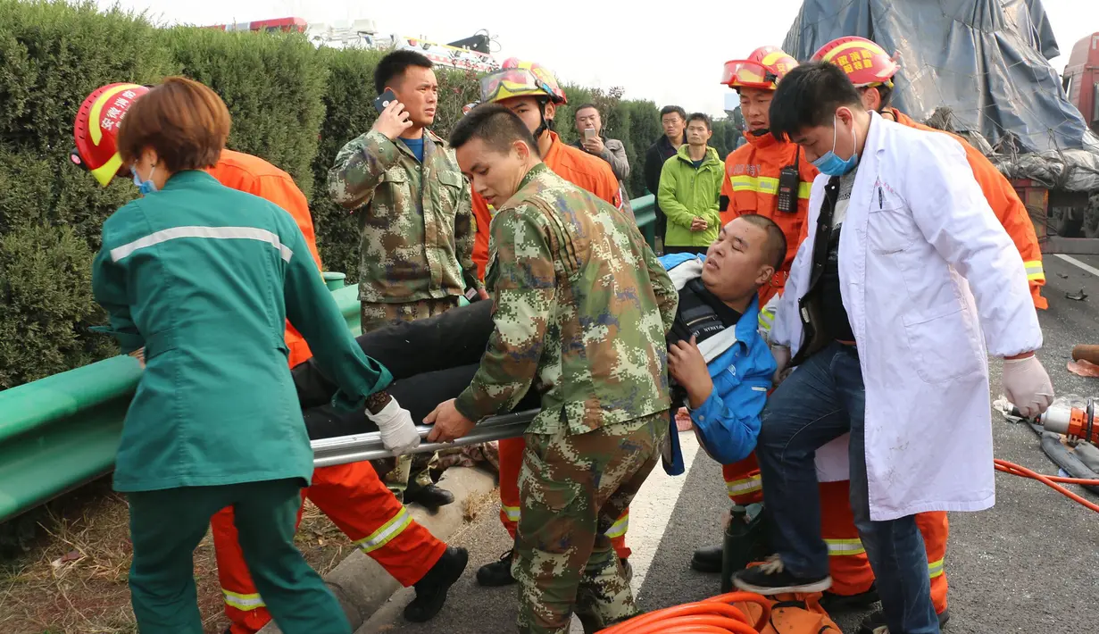 Tim penyelamat mengevakuasi salah satu korban kecelakaan beruntun yang melibatkan 30 kendaraan di jalan raya dekat Yingshang, China timur, Rabu (15/11). Saat kejadian diketahui wilayah lokasi kecelakaan tengah tertutupi kabut tebal. (Chinatopix via AP)