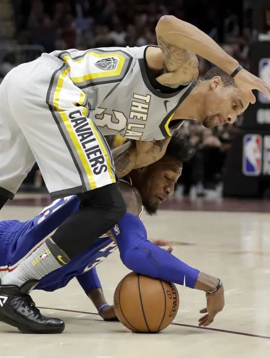 Pemain Cavaliers, George Hill (atas) berebut bola dengan pemain Philadelphia 76ers, Robert Covington pada NBA basketball game di Quicken Loans Arena, Cleveland,  (1/2/2018).  Cavs kalah 97-108. (AP /Tony Dejak)