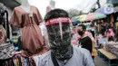Pedagang menggunakan alat pelindung wajah (Face Shield) saat berjualan di Kawasan Tanah Abang, Jakarta, Senin (18/5/2020). Penggunaan alat pelindung wajah itu sebagai upaya untuk melindungi diri saat berhubungan dengan pembeli dalam pecegahan penyebaran COVID-19. (Liputan6.com/Faizal Fanani)