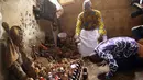 Lucien Yekpon, seorang dukun Lome bersama pasiennya yang sedang membungkuk di depan benda-benda jimat di pasar Akodessewa di Togo, Afrika, 5 Agustus 2015. Pasar ini menjual berbagai benda-benda klenik dan juga peralatan sihir. (AFP PHOTO/EMILE KOUTON) 