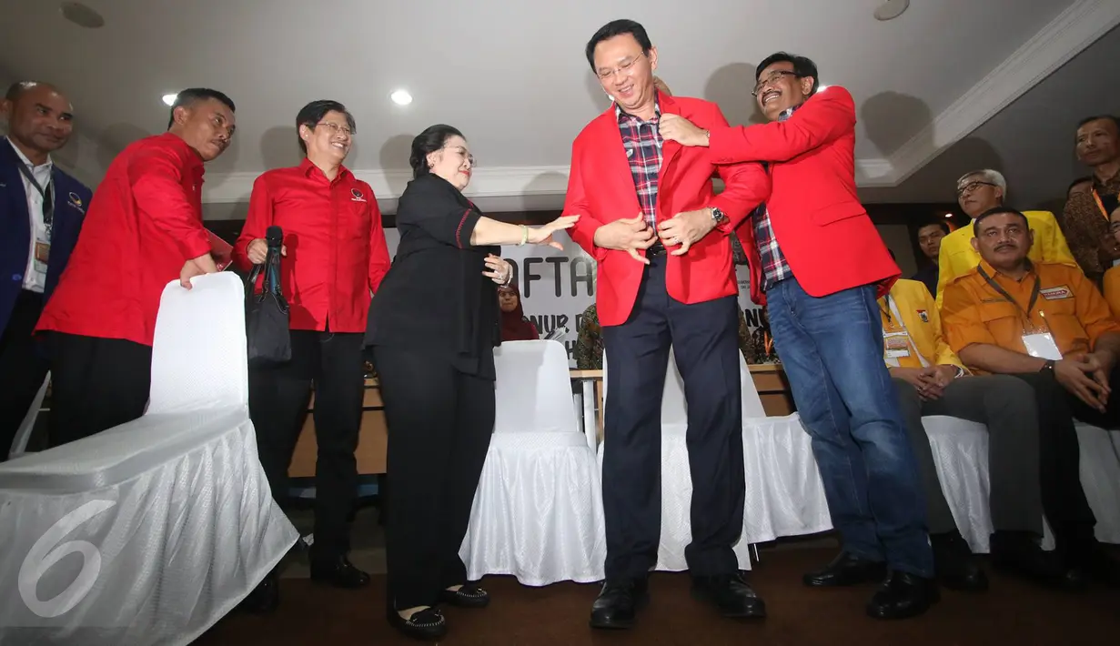 Basuki Tjahaja Purnama (Ahok) dibantu Ketum PDIP Megawati Soekarnoputri dan Djarot Saiful Hidayat mengenakan jas merah tanpa logo PDIP usai mendaftar maju pada Pilkada DKI Jakarta 2017, di KPUD DKI Jakarta, Rabu (21/9). (Liputan6.com/Immanuel Antonius)