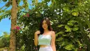 Tampilan feminine Livy Renata memadukan cropped tank top warna hijau dengan fitted skirt warna putih dan pointy flat shoes. (Instagram/livyrenata).