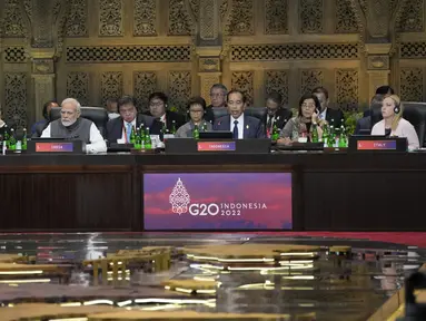 Presiden Indonesia Joko Widodo atau Jokowi berbicara selama pembukaan Konferensi Tingkat Tinggi atau KTT G20 hari pertama di Nusa Dua, Bali, Selasa (15/11/2022). Jokowi terlihat didampingi Menteri Luar Negeri Retno Marsudi di sisi kanan, dan Menteri Keuangan Sri Mulyani Indrawati di sisi kiri. (AP Photo/Dita Alangkara, Pool)
