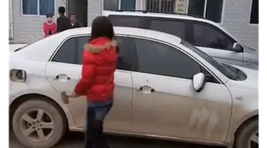 Dengan menggunakan palu besar, wanita asal China ini menghancurkan seluruh bagian kaca mobil