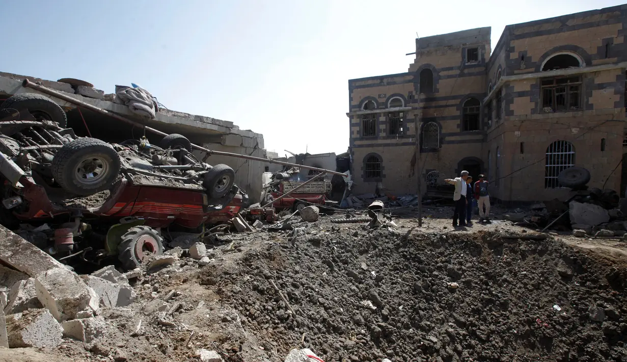 Warga berada di sebuah rumah yang hancur akibat serangan udara yang dipimpin koalisi militer Saudi di Kota Sanaa, Yaman, (4/9). Serangan udara Saudi tersebut banyak  menewaskan warga sipil yang tak berdosa. (REUTERS/Mohamed al-Sayaghi)