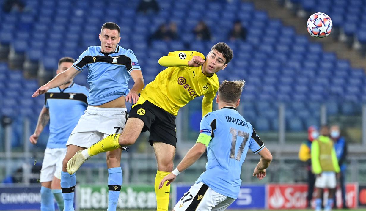 Gelandang Lazio, Adam Marusic, berebut bola dengan penyerang Borussia Dortmund, Giovanni Reyna, pada laga Grup F Liga Champions 2020/2021 di Stadion Olimpico, Rabu (21/10/2020) dini hari WIB. Lazio menang 3-1 atas Borussia Dortmund. (AFP/Alberto Pizzoli)