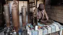 Seorang pengarajin yang bernama Abu Ali al-Bitar menyusun bekas peluru untuk menciptakan karya seni di Damaskus, Suriah (20/4). Abu Ali al-Bitar mengumpulkan puluhan puing roket dan bekas amunisi untuk dijadikan sebuah karya seni. (AFP/Sameer Al-Doumy)