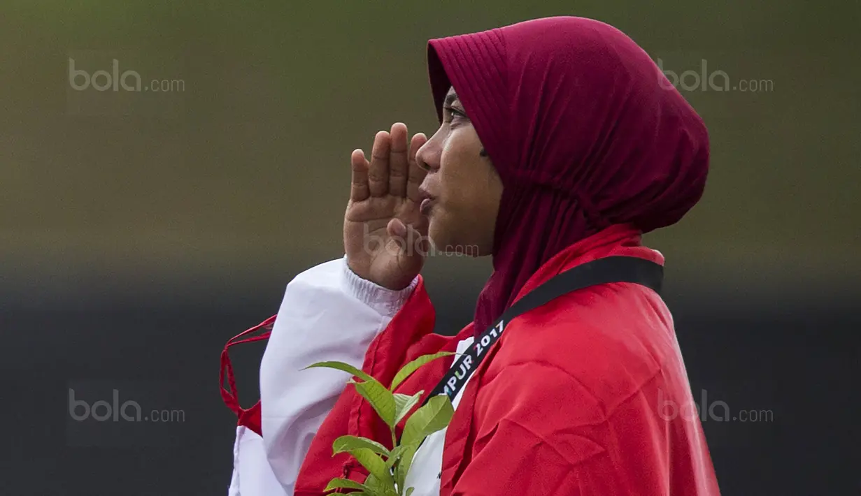 Pepanah putri Indonesia, Sri Ranti, saat prosesi pengalungan medali pada SEA Games cabang panahan nomor compound di National Sports Council, Kuala Lumpur, Rabu (16/8/2017). Dirinya meraih emas pertama untuk Indonesia. (Bola.com/Vitalis Yogi Trisna)