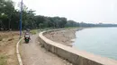 Pengendara motor melintas di kawasan Waduk Cincin, Jakarta, Selasa (8/1). Pemerintah Kota Administratif Jakarta Utara berencana menata kawasan Hutan Kota Waduk Cincin yang berlokasi di kawasan Sunter, Jakarta Utara. (Liputan6.com/Herman Zakharia)