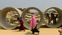 Sejumlah bocah pengungsi Rohingya bermain di pipa limbah di kamp pengungsi Kutupalong, Bangladesh (5/4). Rencananya para pengungsi Rohingya ini akan dipindahkan ke sebuah pulau terpencil di Bangladesh. (AFP Photo/Munir Uz Zaman)