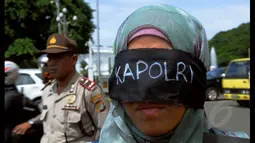 Seorang Wanita yang tergabung dalam Koalisi Masyarakat Sipil melakukan aksi tutup mata menolak pencalonan Kapolri, Jakarta, Rabu (21/1/2015). Aksi dilakukan untuk menolak pencalonan Komjen Budi Gunawan (BG) menjadi Kapolri. (Liputan6.com/Faisal R Syam)