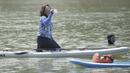 Menteri Kelautan dan Perikanan, Susi Pudjiastuti, melepas dahaga saat bermain paddle board di Danau Sunter, Jakarta, Minggu (25/2/2018). Kegiatan ini dilakukan dalam rangka Festival Danau Sunter. (Bola.com/Okie Prabhowo)