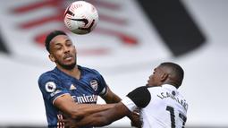Penyerang Arsenal, Pierre-Emerick Aubameyang, berebut bola dengan penyerang Fulham, Ivan Cavaleiro, pada laga Liga Inggris di Craven Cottage, London, Sabtu (12/9/2020) malam WIB. Arsenal menang 3-0 atas Fulham. (Ben Stansall/Pool via AP)