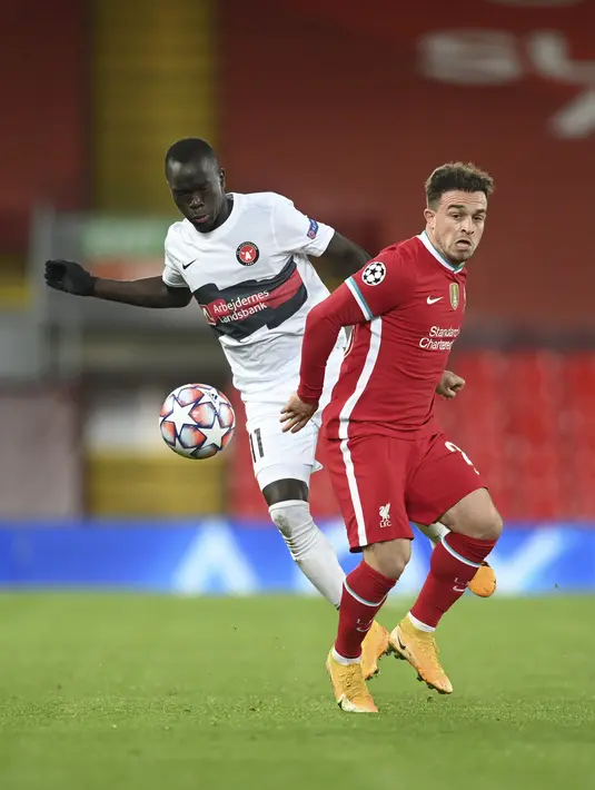 Gelandang Liverpool, Xherdan Shaqiri berebut bola dengan pemain Midtjylland, Awer Mabil pada pertandingan grup D Liga Champions di stadion Anfield, di Liverpool, Inggris, Selasa (27/10/2020). Liverpool menang 2-0 atas Midtjylland. (Michael Regan/Pool via AP)